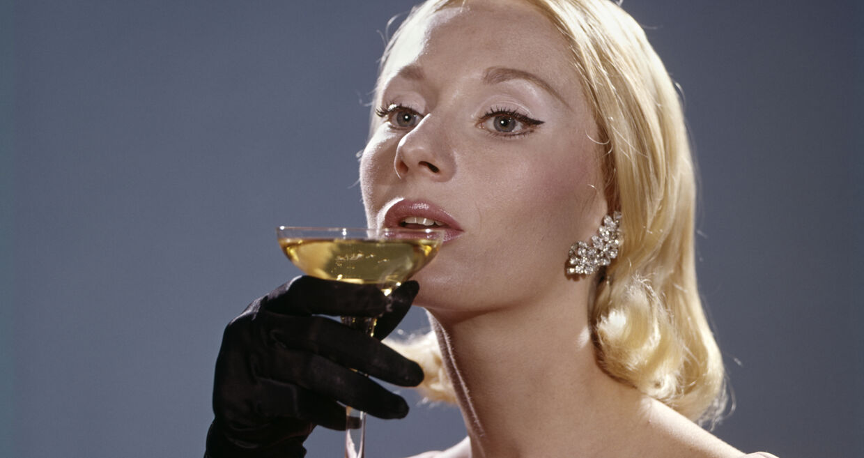 Mulher bebe champanhe com luvas e vestido elegante