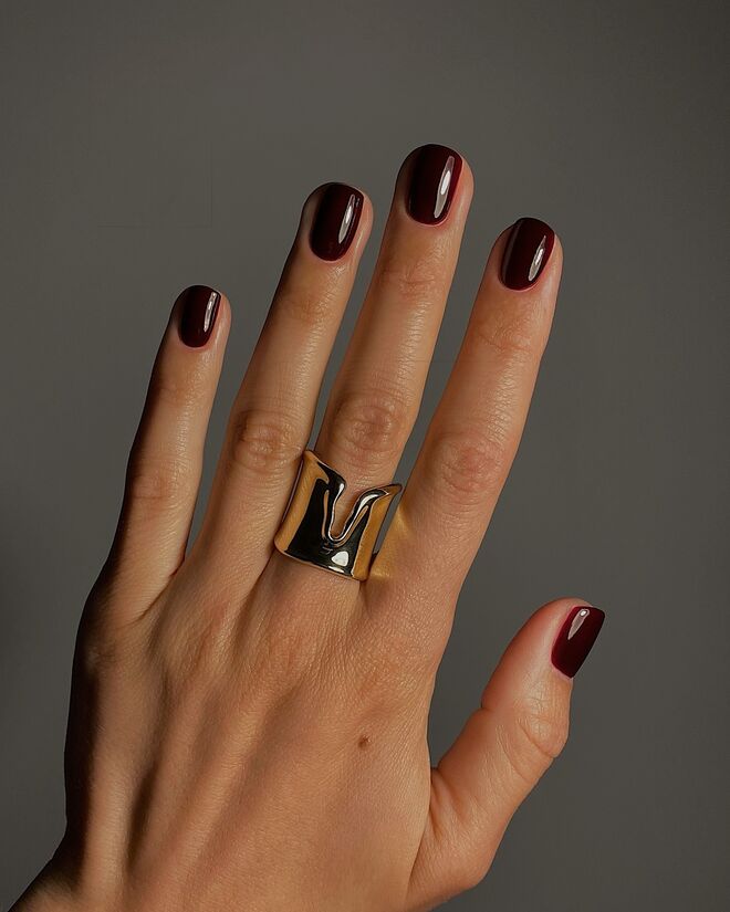 Uma aposta segura e ganha: unhas curtas e muito elegantes, em bordeaux brilhante..