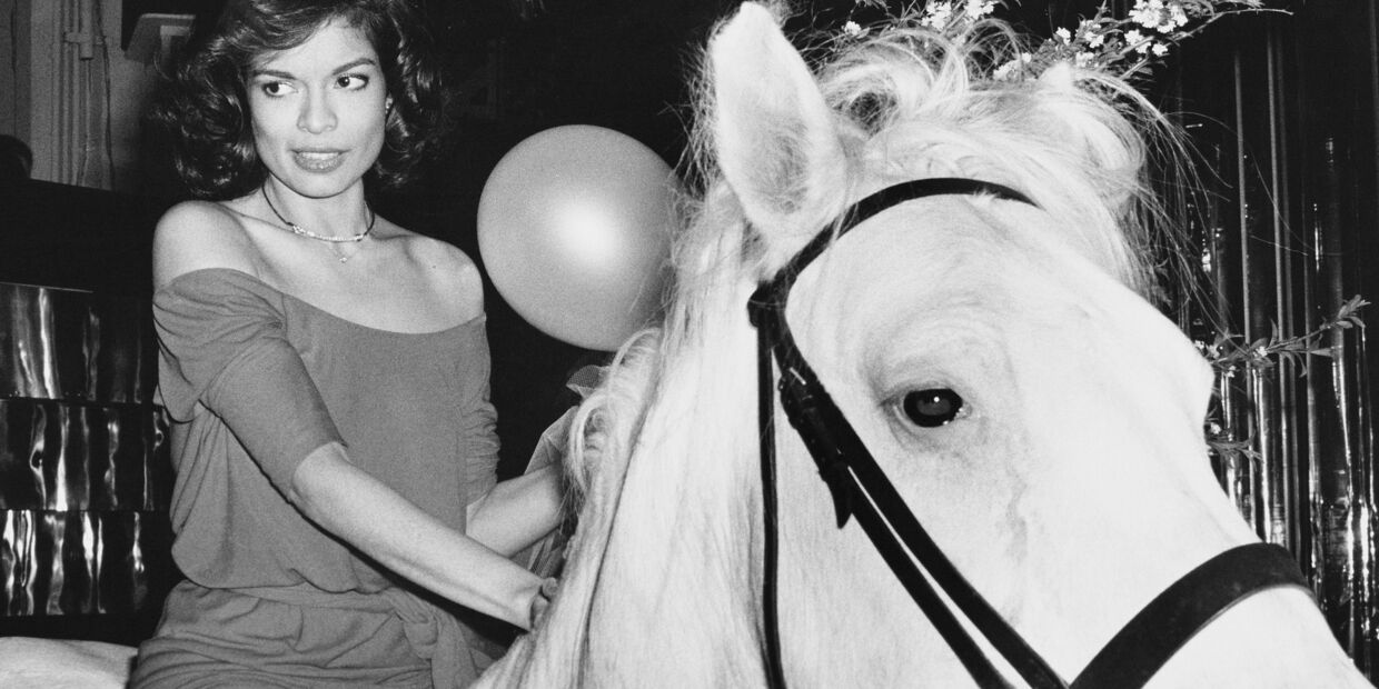 Mulher a cavalo com balão e flores no contexto do Ano do Cavalo.
