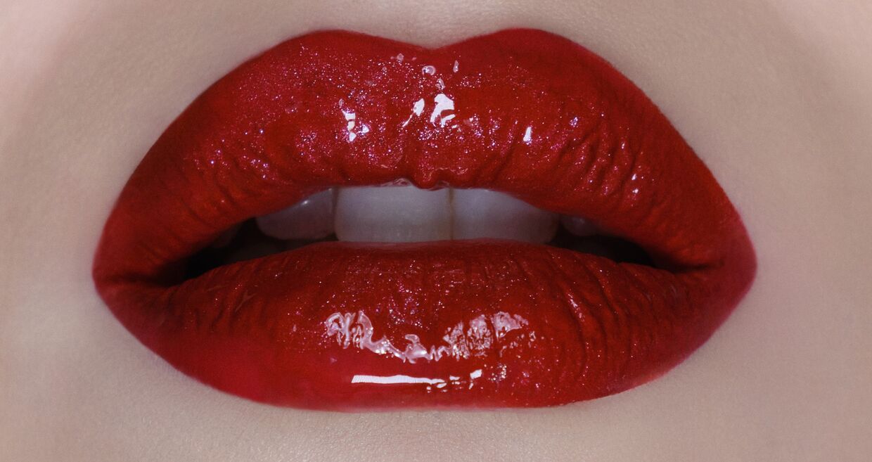 Lábios vermelhos brilhantes destacam cores e impacto em maquilhagem
