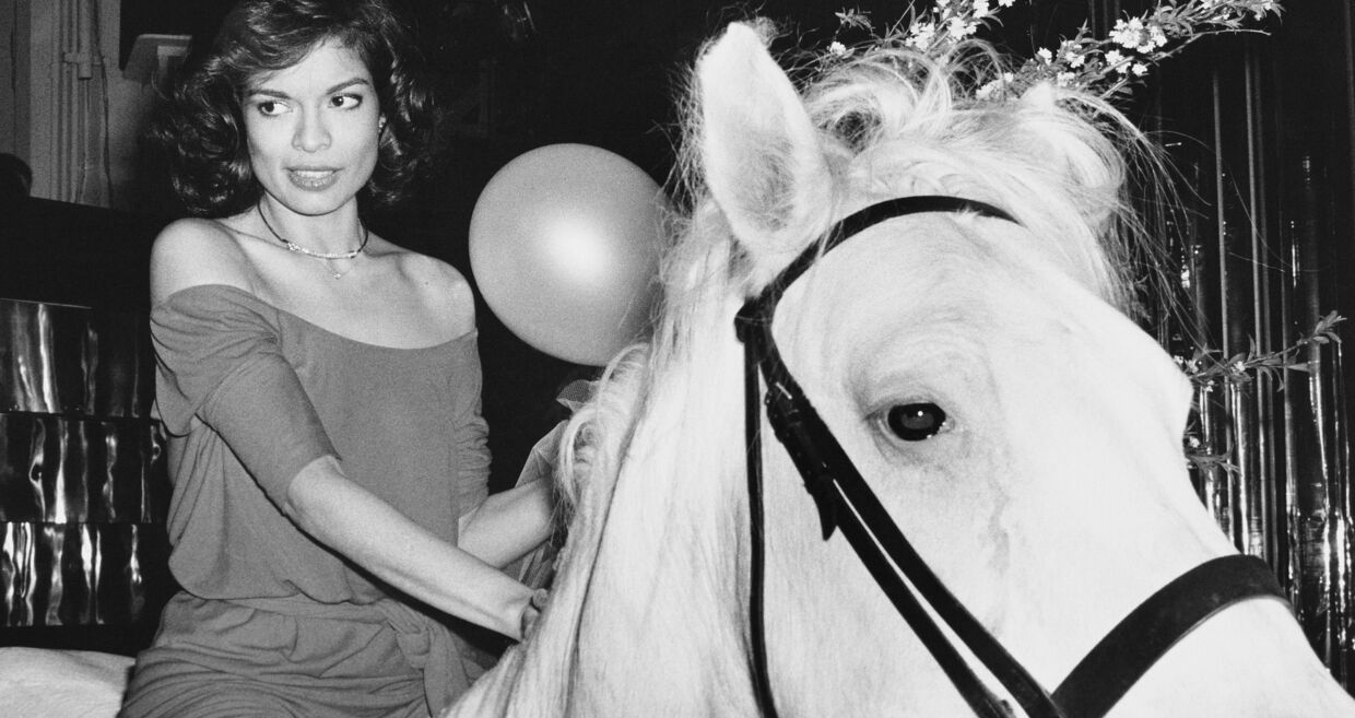 Mulher a cavalo com balão e flores no contexto do Ano do Cavalo.
