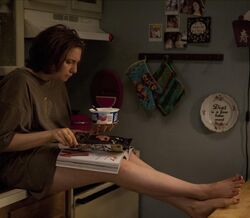 Mulher lê revista enquanto come iogurte