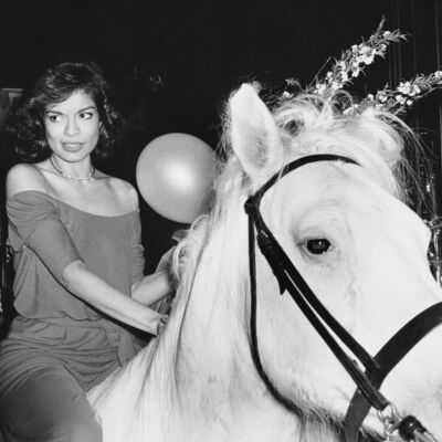 Mulher a cavalo com balão e flores no contexto do Ano do Cavalo.
