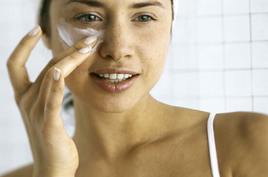Creme antirrugas: mulher aplica produto facial