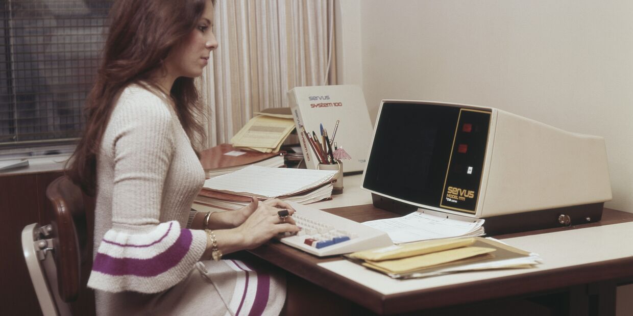 Mulher trabalha num computador Servus System 100, num escritório dos anos 70