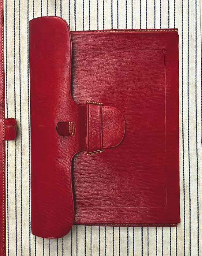 A Moynat cultiva a arte do detalhe desde a sua origem. O envelope de couro vermelho é um elemento distintivo de alguns baús, utilizado para guardar artigos delicados ou preciosos, como documentos de viagem