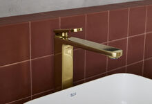 Torneira dourada Roca destaca-se numa casa de banho moderna, renovando o espaço