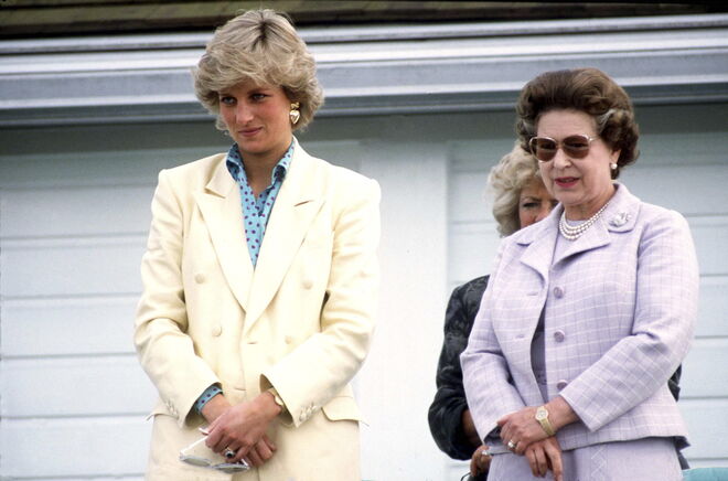 Princesa Diana veste um fato amarelo e uma camisa com padrão polka dots, ao seu lado está a Rainha Elizabeth. 