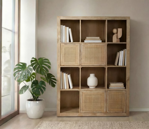 Estante de madeira com livros, vaso e planta monstera num ambiente acolhedor