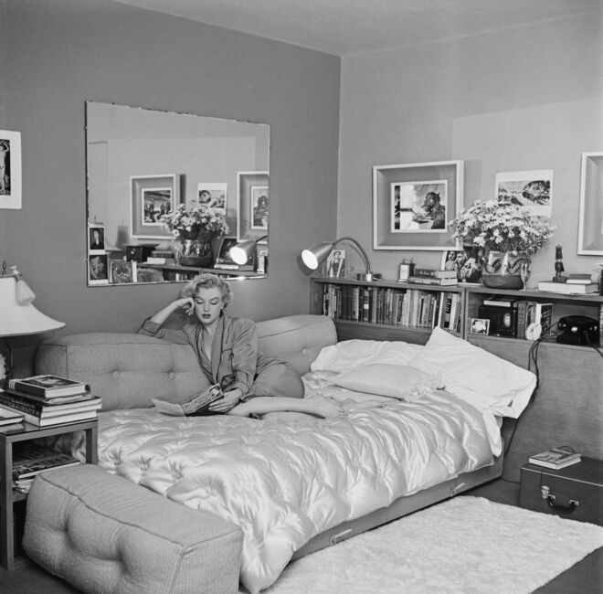 Marilyn Monroe adorava ler — a sua biblioteca pessoal contava com mais de 400 títulos. Aqui vemo-la num sofá-cama, com o livro “The Poetry and Prose of Heinrich Heine”, de Frederic Ewen, por volta de 1951.