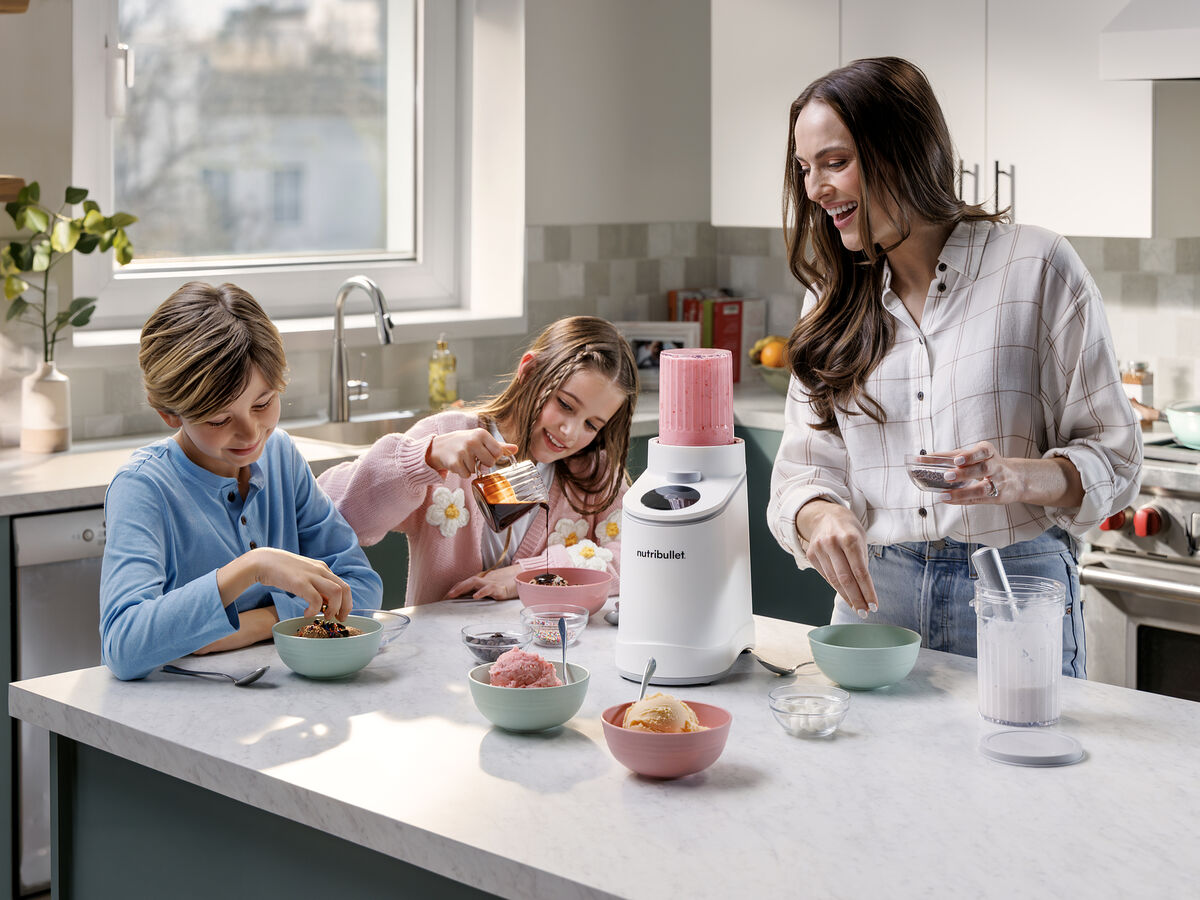 Mulher e duas crianças preparam gelado em casa com a Nutribullet