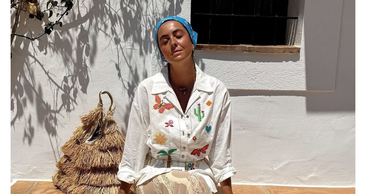 Mulher usa roupa com bordados de cactos e borboletas, combinada com saia de renda