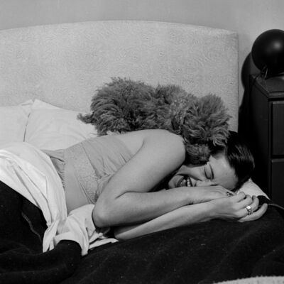 Uma mulher dorme com o seu cão na cama