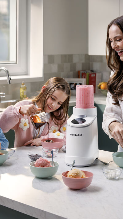 Mulher e duas crianças preparam gelado em casa com a Nutribullet
