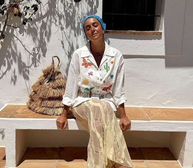 Mulher usa roupa com bordados de cactos e borboletas, combinada com saia de renda