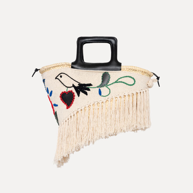 Mulher usa roupa com bordados de cactos e borboletas, combinada com saia de renda